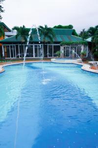 波尔多·格尼拉La Solana Suites and Resorts by Cocotel的一座大楼前带喷泉的大型游泳池