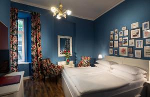 维也纳尤尼娅酒店的一间卧室设有一张床和蓝色的墙壁