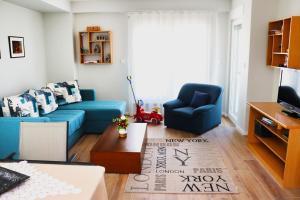 斯科普里Foxxy Luxury Apartments的客厅配有蓝色的沙发和蓝色的椅子
