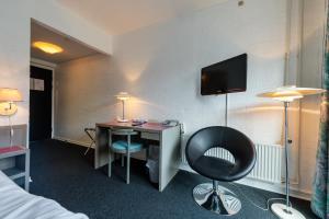 莱姆维HotelVFjorden的酒店客房设有一张桌子和一台墙上的电视。