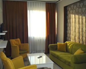 安卡拉Lion City Hotel Ankara的客厅配有绿色沙发和两把椅子