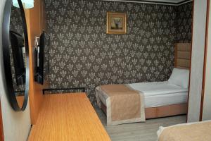 安卡拉Lion City Hotel Ankara的小房间设有一张床和一张小桌子
