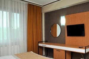 安卡拉Lion City Hotel Ankara的一间卧室配有书桌、镜子和床