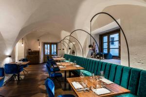 格洛伦萨Flurin Suites的餐厅设有木桌和蓝色椅子