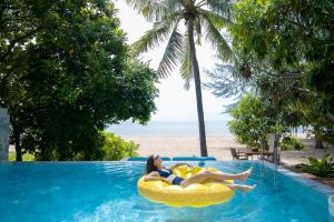 七岩Veranda Resort & Villas Hua Hin Cha Am的两名女性躺在海滩旁的游泳池内