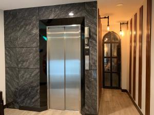 美塞Orasa hotel的走廊上的电梯,有黑色大理石墙壁