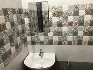 古鲁瓦尤尔LAKSHMI TOURIST HOME的一间带水槽和镜子的浴室