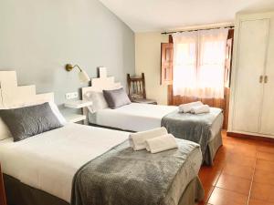 坎德拉里奥Hotel Rural Tia Margot的酒店客房设有两张床和窗户。