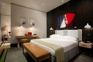 罗马罗马肖像酒店 -鲁嘉尔诺系列酒店的卧室配有一张白色大床和一张书桌