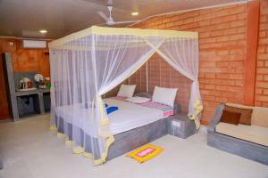 乌纳瓦图纳Greenery Lanka Villa的一间卧室配有天蓬床和沙发