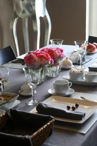 西内B&B LES CRESSES的一张桌子,上面有一张桌子布,上面有玫瑰花,放在中间