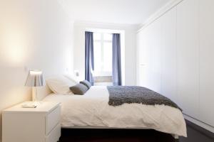 里斯本FLH Baixa Elegant Apartment的白色的卧室设有白色的床和窗户。