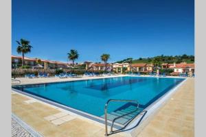拉戈斯Luxury apartment with free use of pool, gym and spa的一座带椅子和棕榈树的度假村游泳池