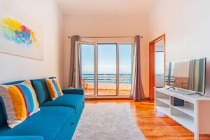 丰沙尔FLH Funchal Ocean View with Pool的客厅配有蓝色的沙发和电视