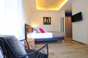 宗扎旅游酒店的一间卧室配有一张床、一台电视和一把椅子