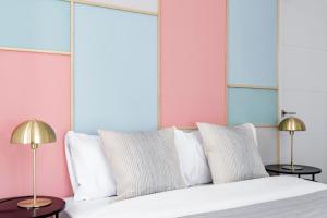 马德里Color Apartments by Olala Homes的一间卧室配有一张带白色枕头的床和两盏灯。
