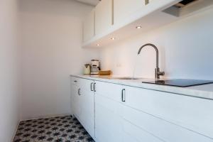 阿波罗尼亚米利亚吉套房公寓的厨房配有白色橱柜和水槽