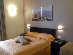 那不勒斯钟楼住宿加早餐旅馆的卧室配有一张床,墙上挂着一幅画