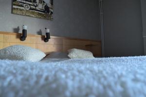 马隆圣奥洛夫酒店 & 餐厅的一张带白色床单和两个白色枕头的床