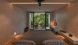 图卢姆Casa Agape Hotel Tulum with Beach Club Access的一间卧室设有一张大床和一个大窗户