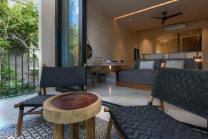 图卢姆Casa Agape Hotel Tulum with Beach Club Access的卧室配有一张床和一张桌子及椅子