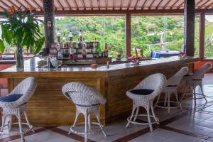 布希奥斯Colonna Galapagos Garden Hotel的度假村内带藤椅的酒吧