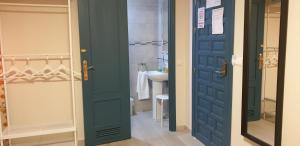 塞维利亚大教堂膳食公寓的浴室设有蓝色门和水槽
