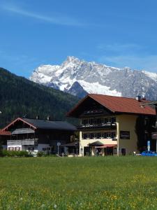 柯尼希斯湖畔舍瑙Sporthotel Schönau am Königssee的一座大建筑,背景是一座山