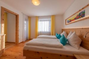 布尔古斯奥Garni Appartements Almrausch的一间卧室配有一张带蓝色枕头的大床