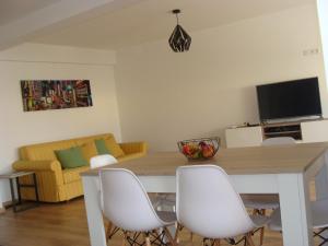 法鲁Casa do Largo的客厅设有餐桌和白色椅子