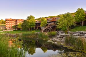 布兰森Hyatt Vacation Club at The Lodges at Timber Ridge的前面有一个池塘的原木房子