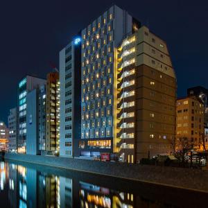 东京Hotel Resol Akihabara的城市的一座建筑,晚上有灯光