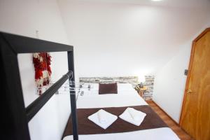 蓬塔阿雷纳斯Tel Hauke Hostal的卧室配有带白色墙壁的双层床