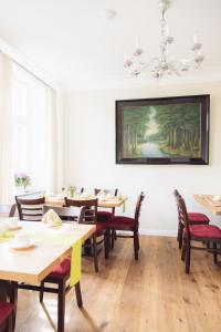 格尔德恩Altes Pfarrhaus的用餐室配有桌椅,墙上挂有绘画作品