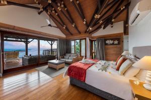Lalomanu阿迦珊瑚礁度假村及Spa酒店的一间带大床的卧室和一间客厅