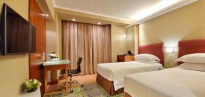 香港粤海华美湾际酒店的酒店客房配有两张床和一张书桌