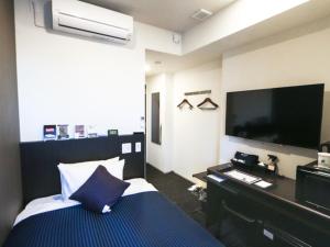 东京HOTEL LiVEMAX Shinjuku EAST的配有一张床和一台平面电视的酒店客房