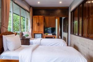 达叻府达勒班里纳度假村的一间卧室配有两张床和电视