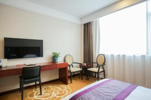 上海新爵加一酒店的酒店客房配有带电视和椅子的书桌