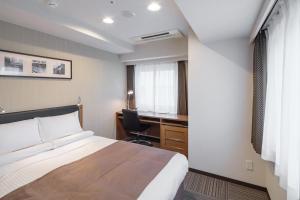 东京MYSTAYS 蒲田酒店的配有一张床和一张书桌的酒店客房