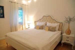卢布尔雅那维拉明卡公寓式酒店的卧室配有一张白色大床,上面有两个黄色标志