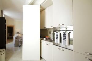 罗马克里斯皮豪华公寓 - 我的额外之家的厨房配有白色橱柜和炉灶烤箱。