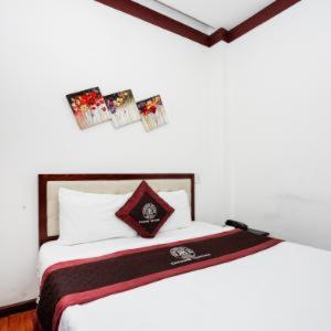 岘港布朗槟2号酒店的卧室配有一张墙上挂有照片的床