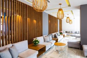 巴利恩Atali Grand Resort的客厅配有白色的沙发和桌子