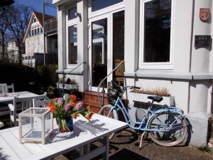 蒂门多弗施特兰德维拉莫温斯坦恩度假村的一辆自行车停在房子旁边,房子里放着鲜花