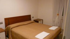TassulloCinzia Dolomiti del Brenta的一间卧室配有一张带两条白色毛巾的床
