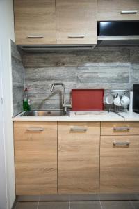 比雷埃夫斯Diamerisma-Grafeio的一个带木制橱柜和水槽的厨房