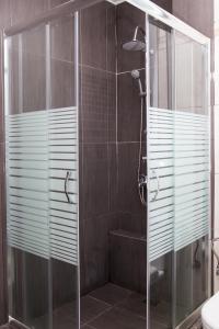 雅典Dimitras Apartment的带淋浴的浴室和玻璃门