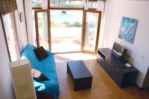 查德尔帕罗奥B16-Dúplex luminoso+ piscina a 150 m del mar的客厅配有蓝色的沙发和电视
