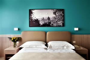 佛罗伦萨拉菲罗酒店的一间卧室配有一张蓝色墙壁的床